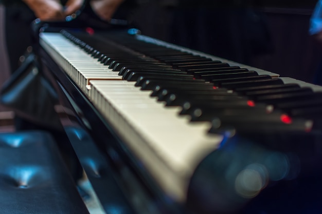 Las teclas del piano en el piano de cola clásico negro juegan una canción clásica