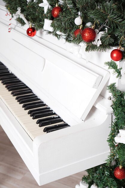 Teclas de piano vertical blanco con decoración navideña con bolas rojas