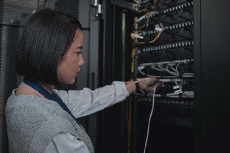 Foto técnica asiática y sala de servidores para redes de cableado o mantenimiento de sistemas en la oficina ingeniera conectando cables para alimentación de servicio de cable o seguridad de datos en administración o gestión de redes