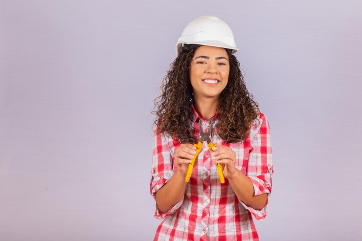 Foto técnica femenina. mujer electricista sobre fondo blanco con espacio para texto.