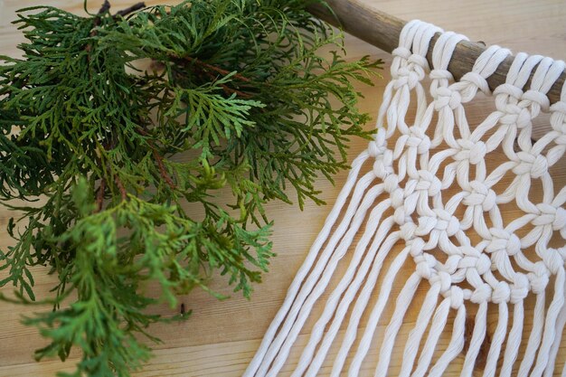 Técnica de macrame para la decoración del hogar y la decoración de la boda acostada en una mesa de madera Un hermoso panel de pared de boho macrame añadirá una atmósfera acogedora