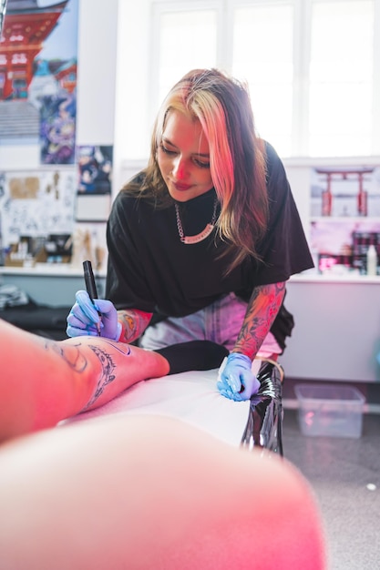 Técnica a mano alzada dibujando un patrón con un marcador azul estudio de tatuajes de tiro vertical