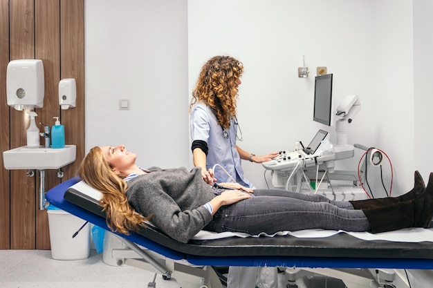 Una técnica médica que conforta a un paciente en una sesión de ultrasonido