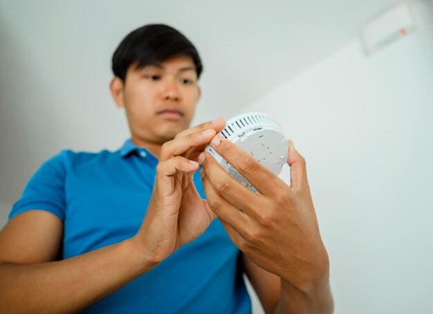 Foto técnico a instalar um detector de segurança contra incêndios num apartamento moderno