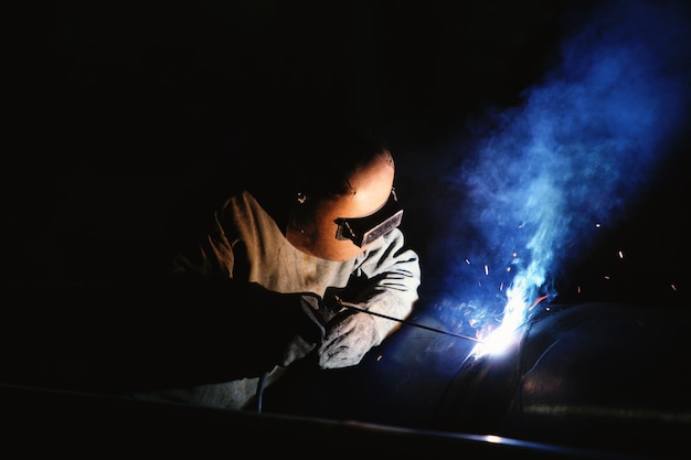 Técnico de acero especializado soldando acero con equipo de seguridad en sitios peligrosos de la industria de la construcción