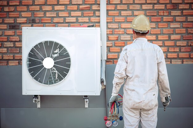 El técnico del aire acondicionado está desarmando el aire acondicionado para su inspección.