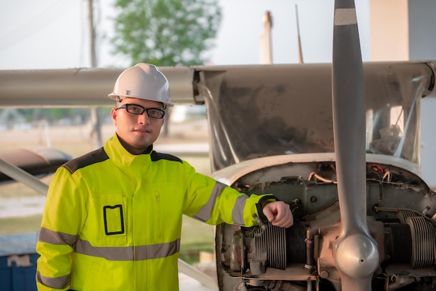 Técnico arreglando el motor del avión. Ingeniería aeroespacial femenina revisando motores de aviones. Mantenimiento mecánico asiático inspecciona el motor del avión