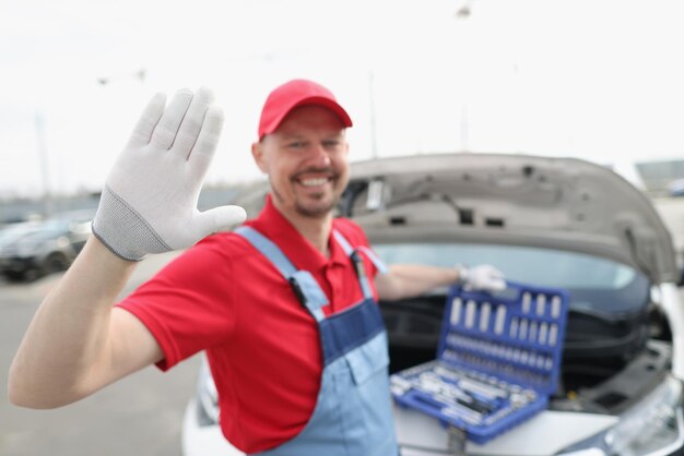 Técnico automotriz saluda y abre el kit lleno de equipos