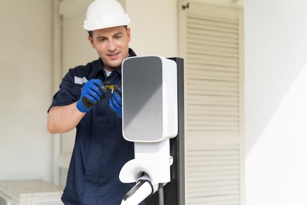 Técnico calificado instala estación de carga de vehículos eléctricos en el hogar proporcionando servicio de mantenimiento para la plataforma de carga de baterías de vehículos eléctricos en el hogar Tecnología de automóviles eléctricos para uso residencial Sincronos