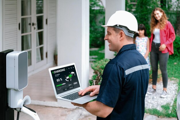 Técnico calificado que trabaja con computadora portátil para la estación de EV doméstica Synchronos