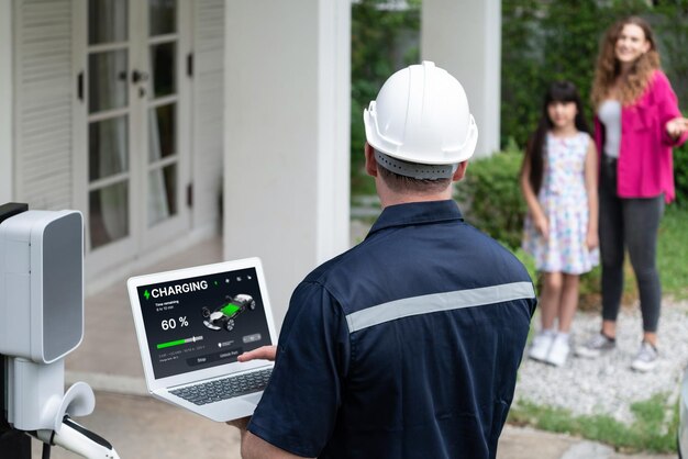 Técnico calificado que trabaja con computadora portátil para la estación de EV doméstica Synchronos