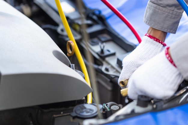 Foto técnico chequea el sistema de aire acondicionado del coche reparador con herramienta de monitor para comprobar y arreglar el coche