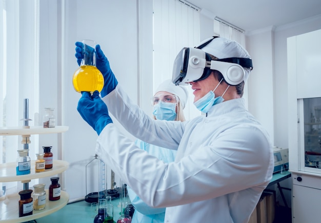 Técnico científico en gafas de realidad virtual examina la droga en el laboratorio.