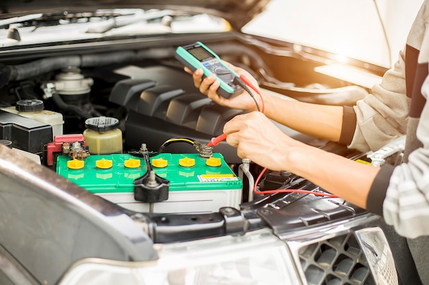 Foto un técnico está comprobando la disponibilidad de la batería del coche.