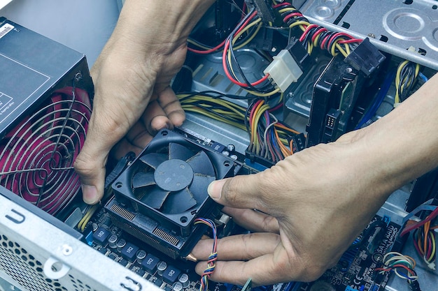 Técnico de computadora que repara la limpieza de la CPU para la computadora en el centro de servicio de computadoras
