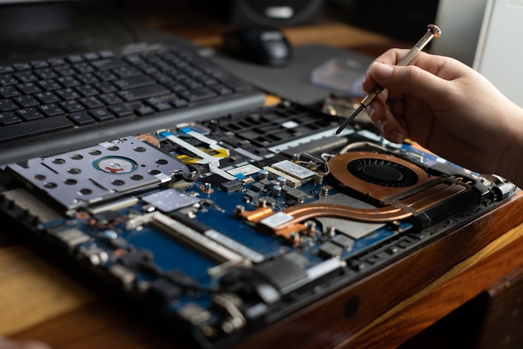 Foto técnico consertando notebook quebrado com chave de fenda