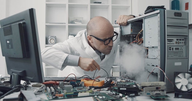 Técnico danificando um computador com uma chave de fenda