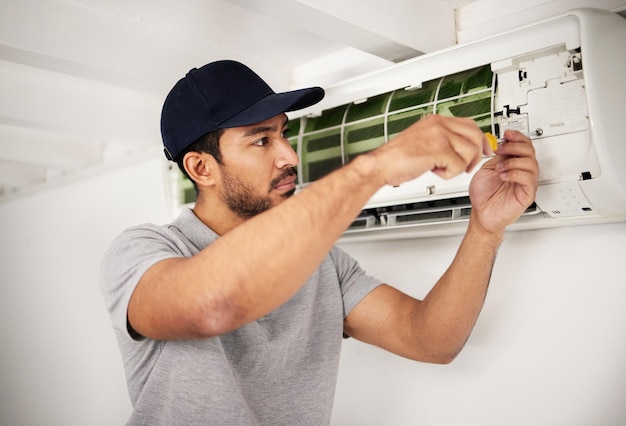 Técnico de ar condicionado de manutenção e homem com chave de fenda trabalhando na ventilação para reparo ac Trabalhador manual empreiteiro ou especialista em máquina de ar condicionado elétrico resolvendo problemas eletricista com ferramentas