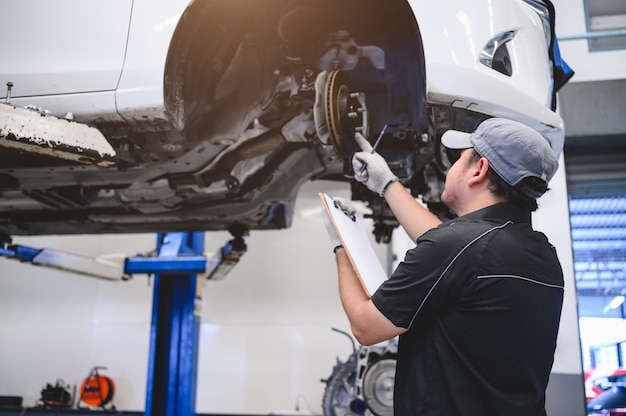 Técnico de automóveis masculino asiático, manutenção de automóveis para clientes de acordo com o veículo especificado