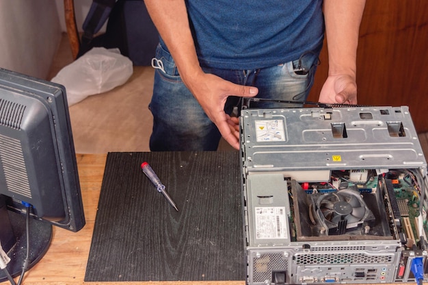 Foto técnico de eletrônica masculina abrindo a caixa do computador