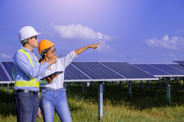 Foto técnico de instrumentos elétricos verificando a manutenção do sistema elétrico no campo de painéis solares