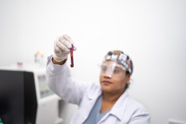 Técnico de laboratório feminino observando que a amostra de sangue está em boas condições