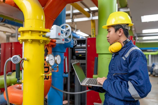 Técnico de manutenção numa central de aquecimento Trabalhadores petroquímicos supervisionam a operação de gasodutos e oleodutos na fábrica Engenheiros colocam protetor auditivo numa sala com muitos tubos