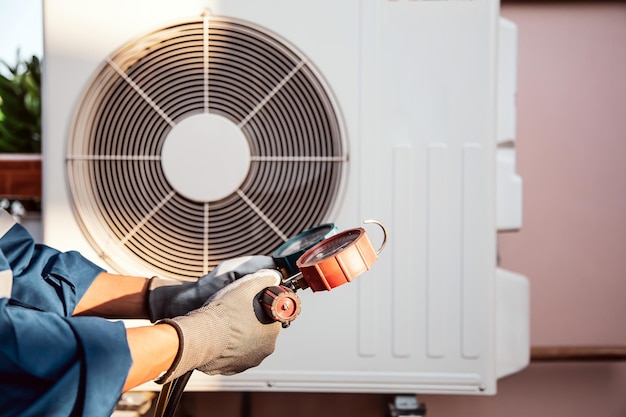 Técnico de mão usando manômetro, verificando o condicionador de ar refrigerante