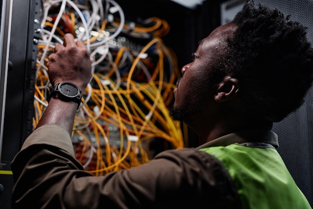 Técnico de rede conectando cabos no data center