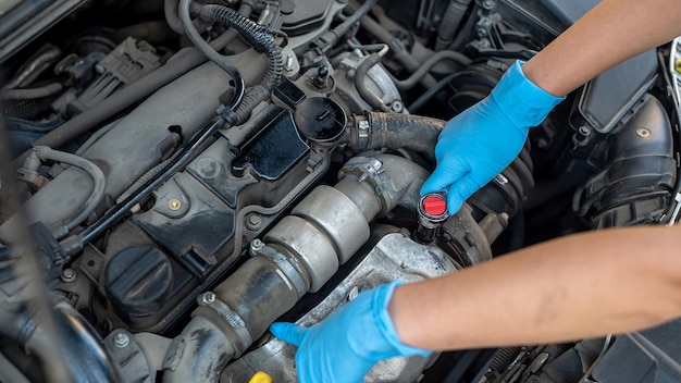 Técnico de serviço de carro feminino inspeciona e repara o carro de um cliente em um centro de serviço de carro