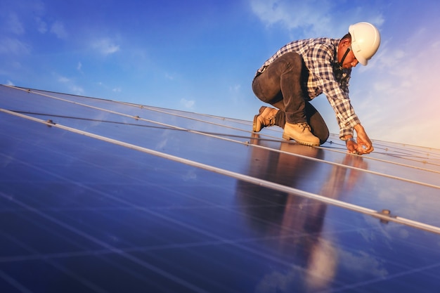 El técnico eléctrico y de instrumentos se ha relajado mientras usa la llave para mantener el sistema eléctrico en el campo del panel solar