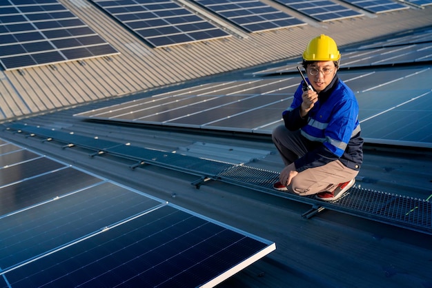 Técnico especialista ingeniero profesional con control de mantenimiento de computadoras portátiles y tabletas instalando un panel de techo solar en la azotea de la fábrica bajo la luz del sol