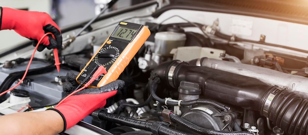 Un técnico está comprobando la disponibilidad de la batería del coche.