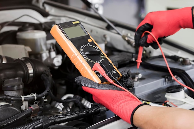 Un técnico está comprobando la disponibilidad de la batería del coche.