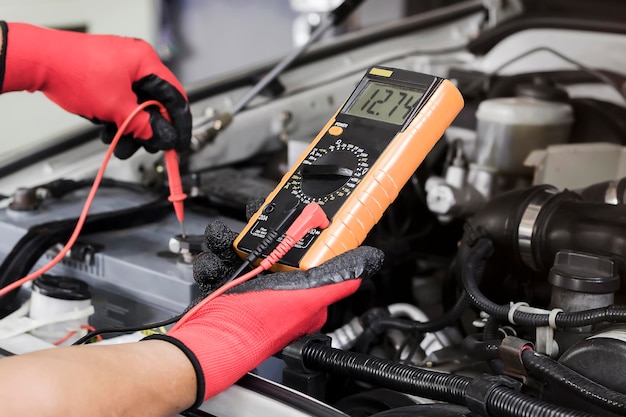 Un técnico está comprobando la disponibilidad de la batería del coche.