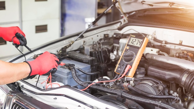 Un técnico está comprobando la disponibilidad de la batería del coche.