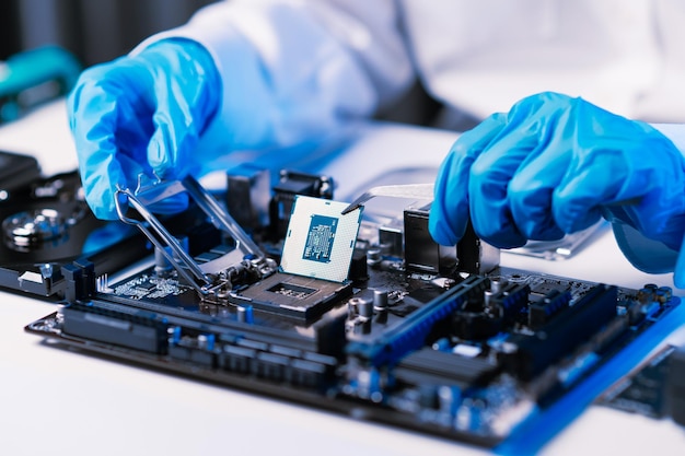 El técnico está poniendo la CPU en el enchufe de la placa base electrónica de la computadora