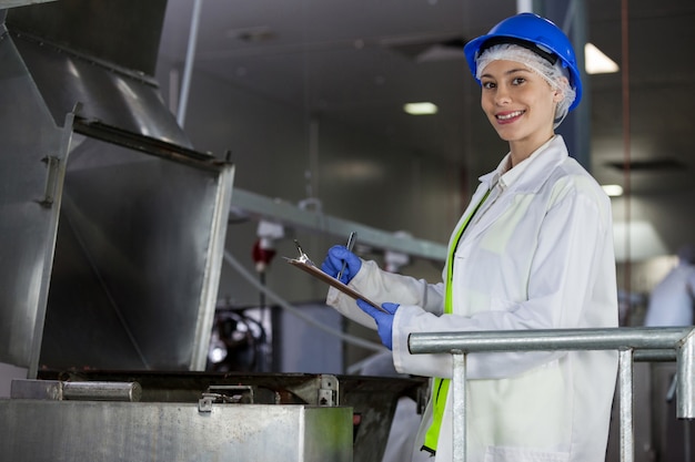 Técnico examinando la máquina procesadora de carne