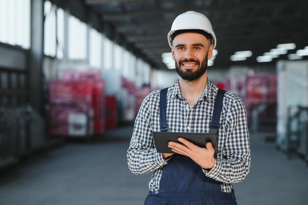 Técnico de fábrica que trabaja con tableta digital en el almacén de la fábrica