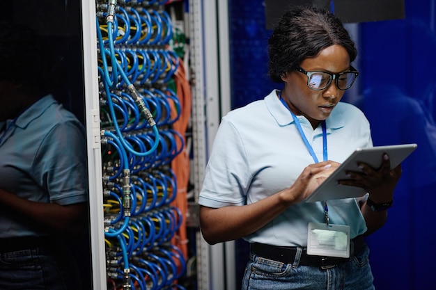 Técnico feminino trabalhando em tablet no data center