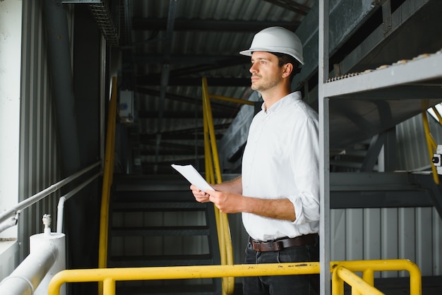 Técnico industrial masculino feliz dentro de una fábrica