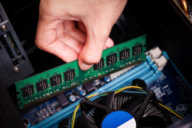 El técnico informático instala una nueva memoria RAM DDR (memoria de acceso aleatorio) en una PC.