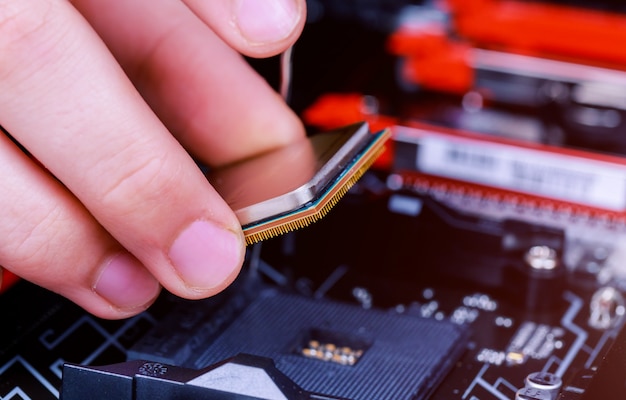 Técnico informático instalando la CPU en la placa base. De cerca.