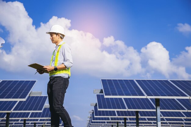 Técnico de instrumentos eléctricos inspeccionando el sistema eléctrico de mantenimiento en el campo de paneles solares