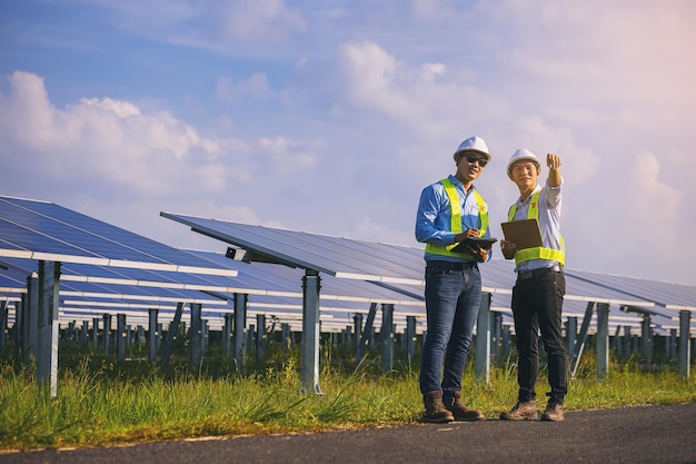 Técnico de instrumentos eléctricos inspeccionando el sistema eléctrico de mantenimiento en el campo de paneles solares