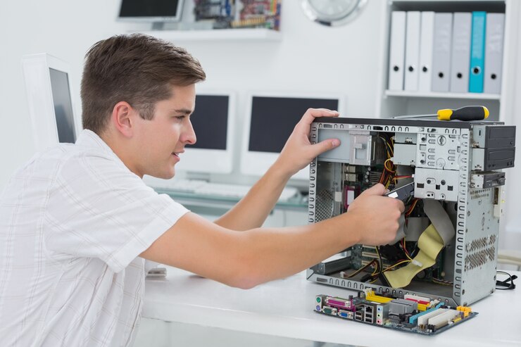 Foto técnico joven que trabaja en la computadora quebrada