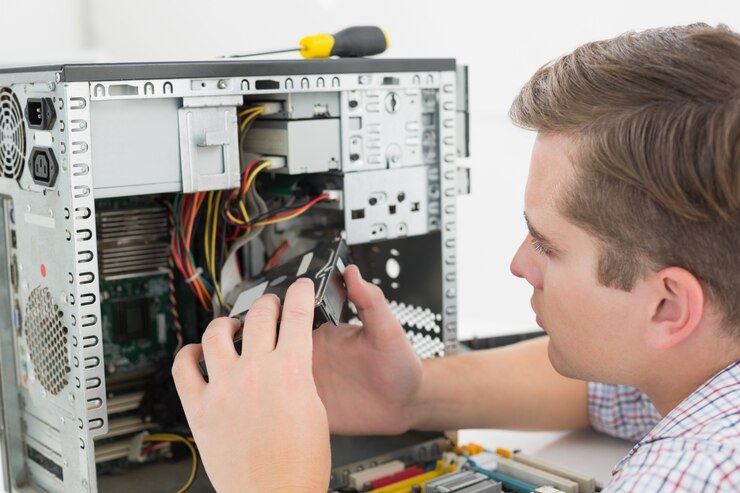 Foto técnico joven que trabaja en la computadora quebrada