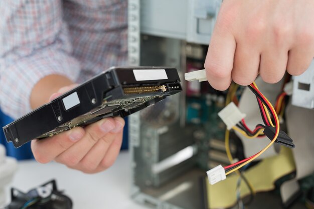 Técnico joven que trabaja en la computadora quebrada