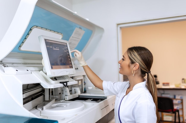 Técnico de laboratorio cargando muestras en un analizador químico