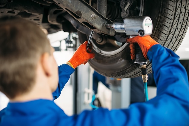 Técnico con una llave para reparar la suspensión.